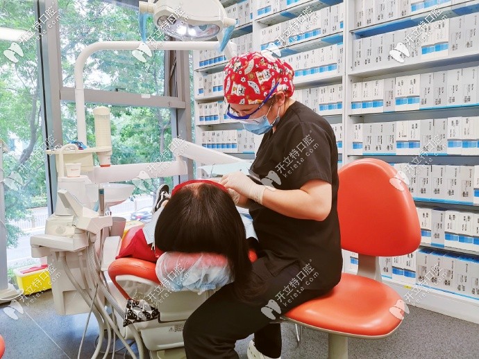 李醫(yī)生正在為正畸復(fù)診顧客檢查口腔情況